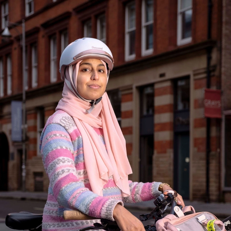 Sarah Jasat in rosa Outfit steht am Fahrrad und schaut sehr cool