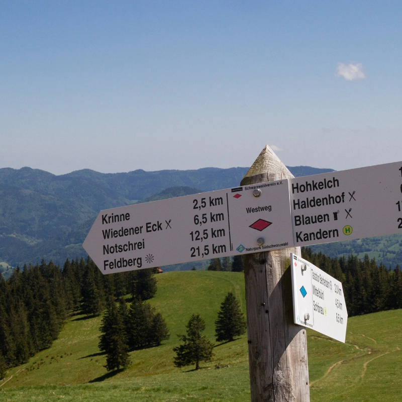 Schild zur Kennzeichung der Wanderwege vor Schwarzwaldkulisse Schild zur Kennzeichung der Wanderwege vor Schwarzwaldkulisse