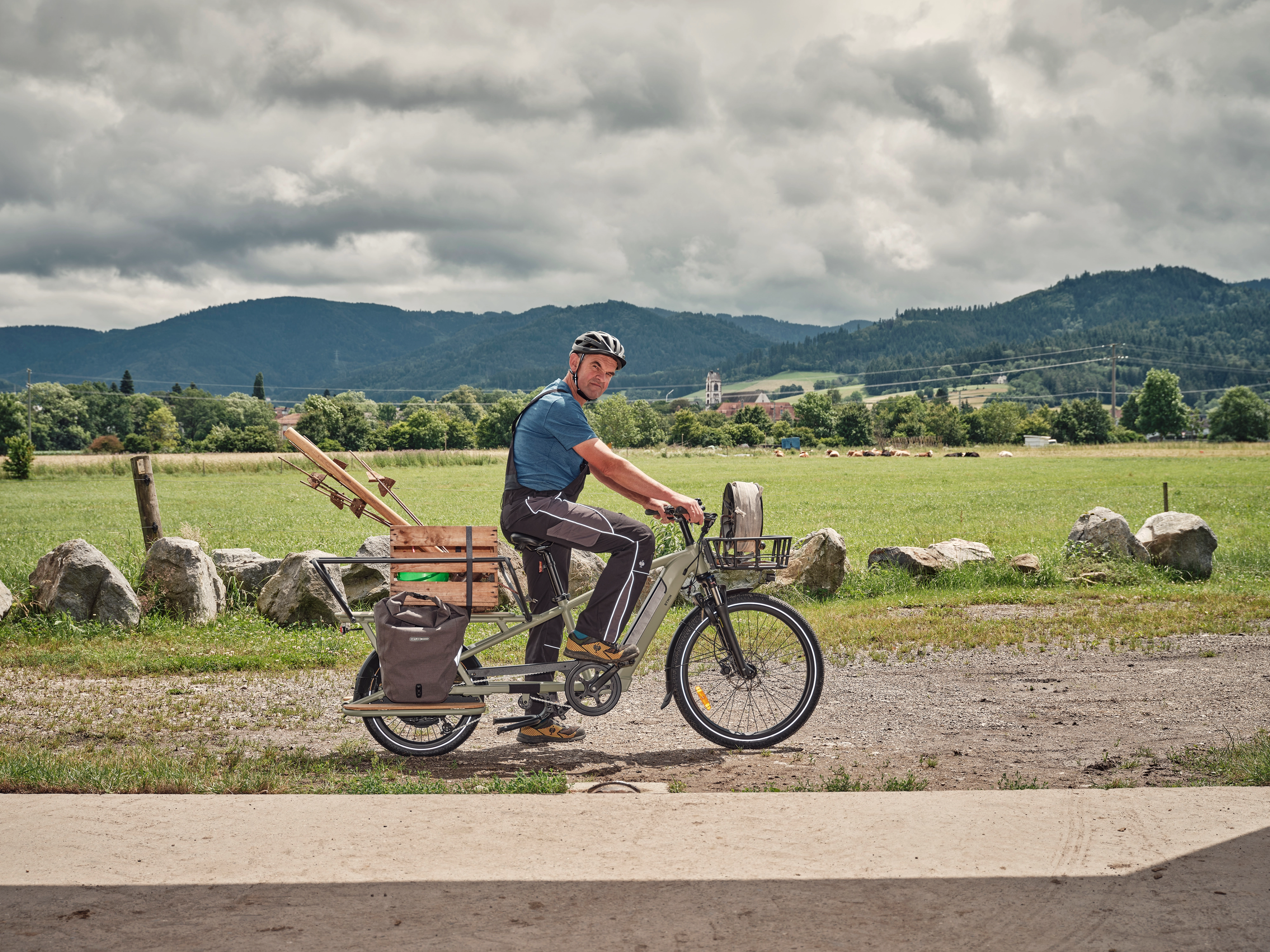 Landwirt mit Longtail im Profil - er hat Material für Einzäunen dabei Landwirt mit Longtail im Profil - er hat Material für Einzäunen dabei